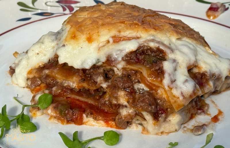 Lasaña de carne recién horneada con queso gratinado y salsa boloñesa casera.
