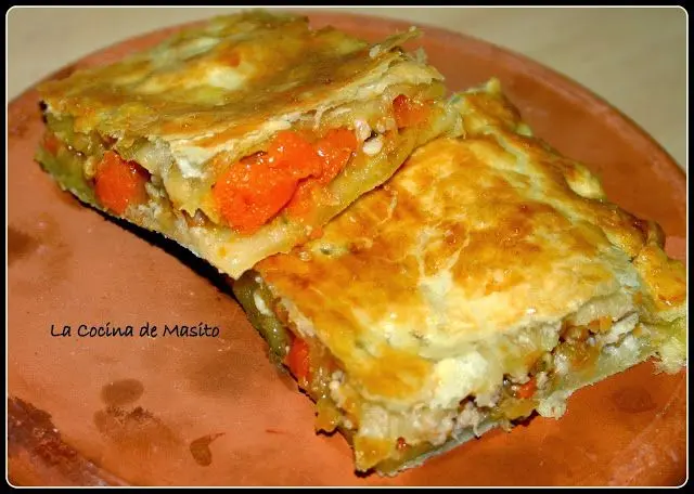 Empanada de pollo con salsa de albóndigas, horneada hasta dorarse, rellena de pollo jugoso y acompañada de una salsa cremosa