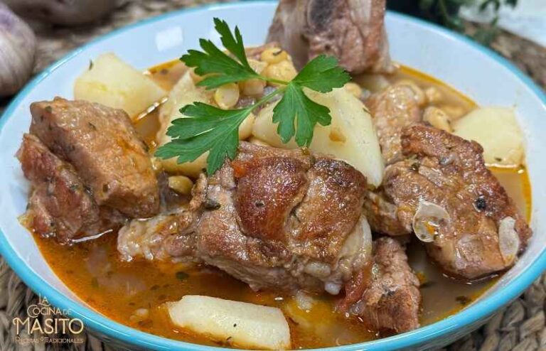 Plato de patatas con costillas y garbanzos en un caldo casero, ideal para comidas reconfortantes.