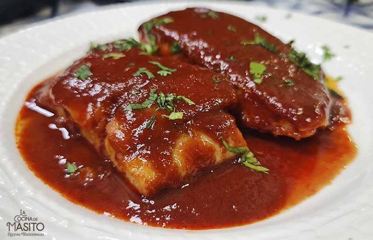 Plato tradicional de bacalao a la vizcaína con salsa de tomate y pimientos.