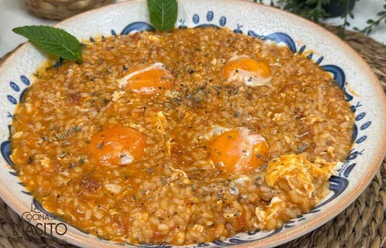 Plato de arroz meloso de tomate servido en un plato hondo con perejil fresco como adorno.