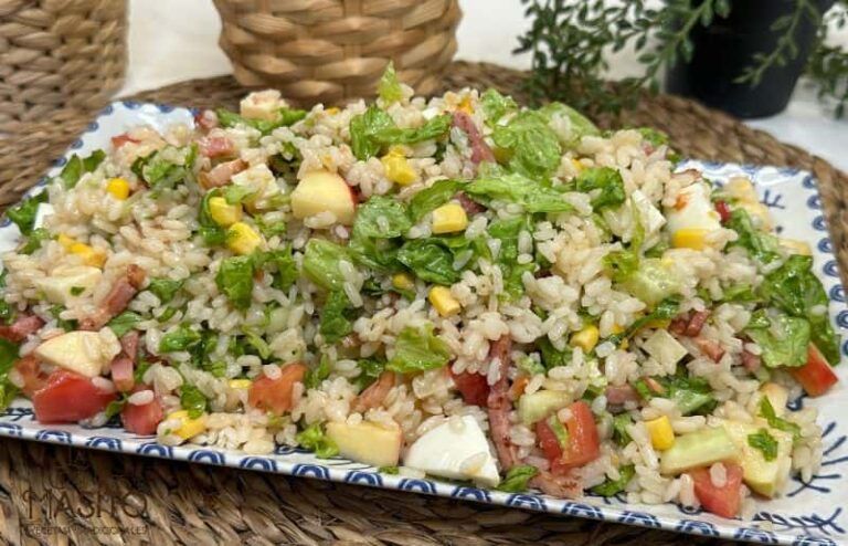Ensalada de arroz colorida con verduras frescas, maíz y aliño ligero en un bol blanco.