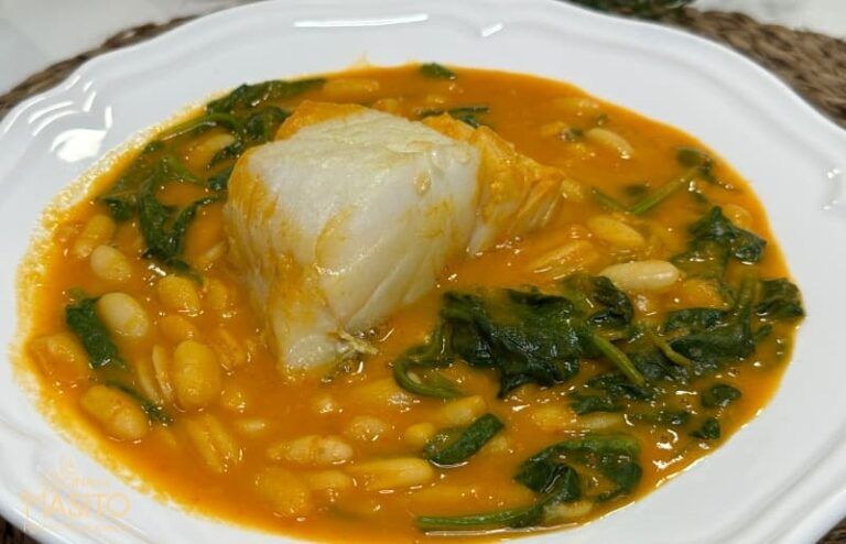 Un plato de potaje de alubias con espinacas y bacalao servido en un cuenco rústico, ideal para los días fríos.
