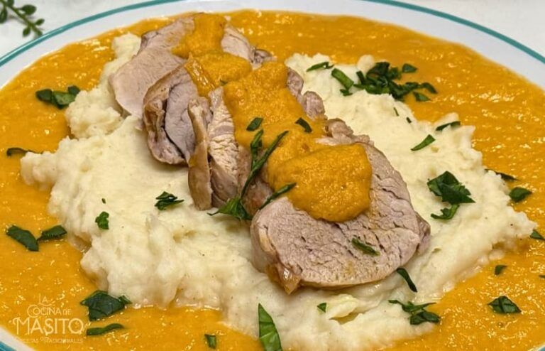 Plato de solomillo de cerdo en salsa acompañado de cremoso puré de patatas servido en una presentación elegante.