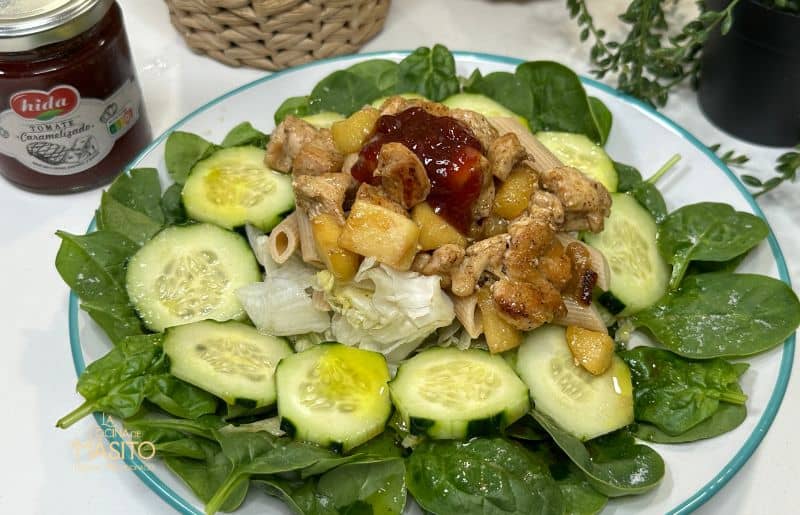 Plato fresco de ensalada de pasta con trozos de pollo, verduras y aderezo cremoso.