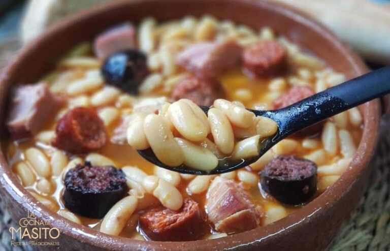 Plato de fabada asturiana cocinada al horno de leña, servido en una cazuela de barro con chorizo, morcilla y fabas tradicionales.