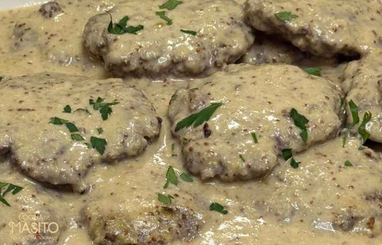 Foto de filetes rusos bañados en una cremosa salsa de miel y mostaza, acompañados de guarnición.