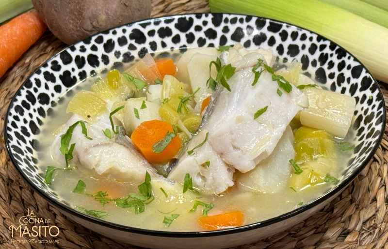Plato de porrusalda con bacalao servido en un cuenco, con puerros, patatas y un caldo caliente.