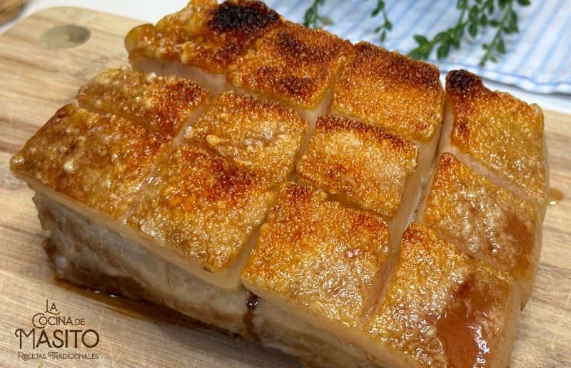 Torreznos de panceta crujientes servidos en un plato rústico.