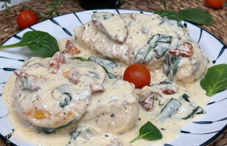 Plato de pollo a la toscana con salsa cremosa de tomate, espinacas y ajo, servido en una sartén rústica.