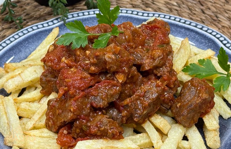 Plato de carne con tomate casera estilo andaluz servida en cazuela