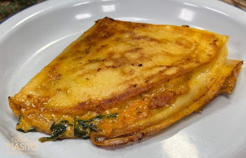 Imagen de crepes rellenos de bacon, servidos en un plato con un toque de queso derretido y decorados con perejil fresco.