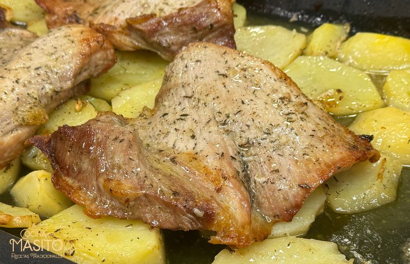 Secreto de cerdo al horno acompañado de patatas doradas y especiadas
