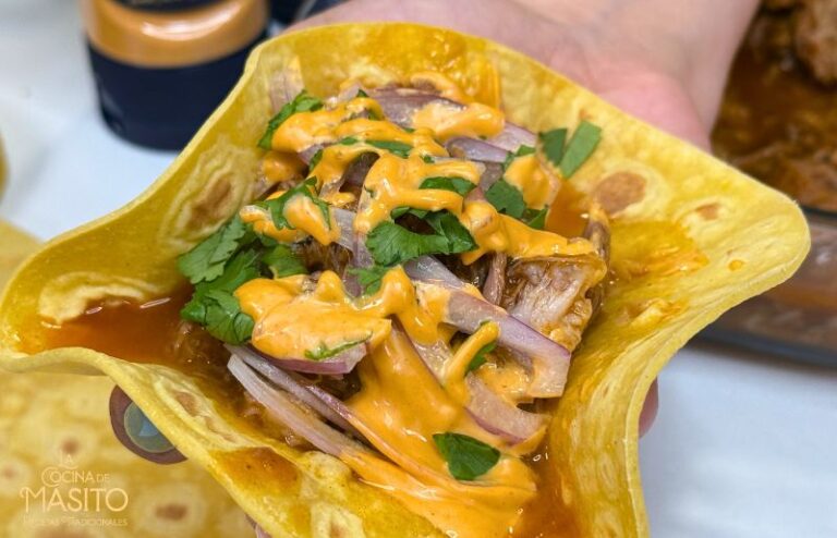 Tacos de codillo desmenuzado con salsa de chipotle ahumado sobre tortillas de maíz