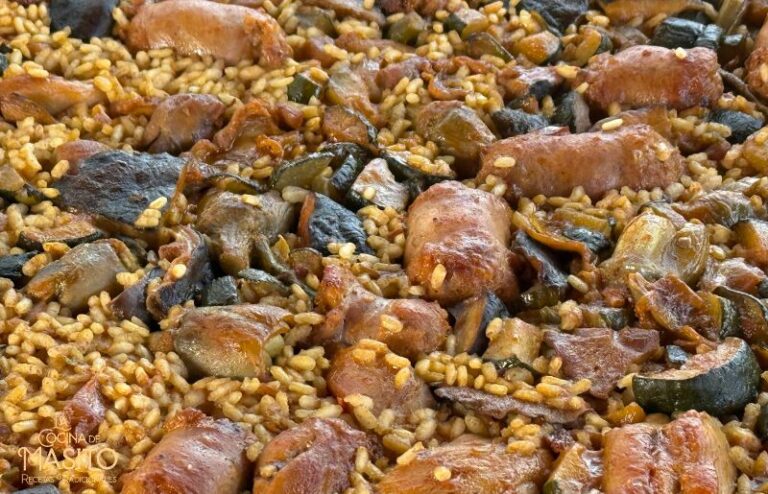 Paella de pollo y butifarra con verduras cocinada en paellera tradicional