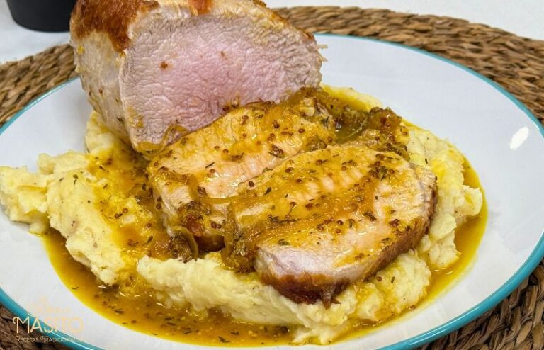Lomo de cerdo en salsa de naranja, miel y mostaza servido en rodajas con salsa por encima