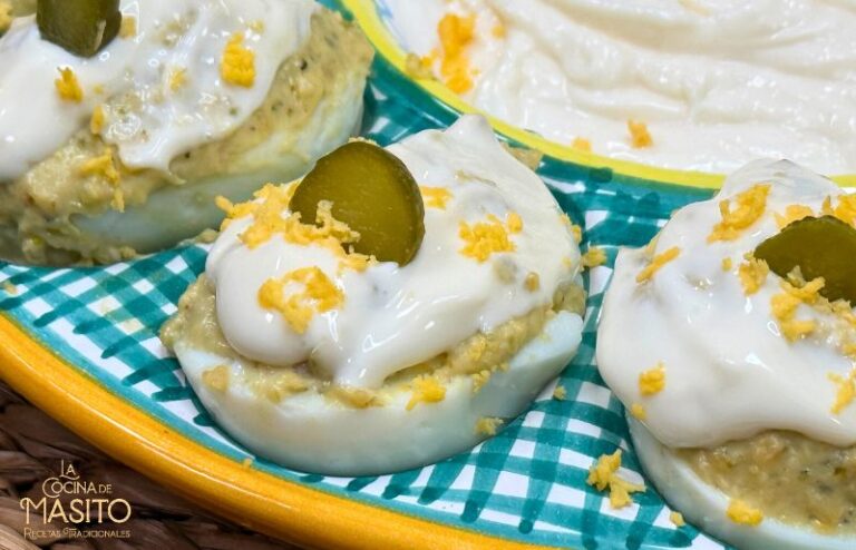 Huevos cocidos rellenos con carne de alitas de pollo desmenuzada y decorados con mayonesa