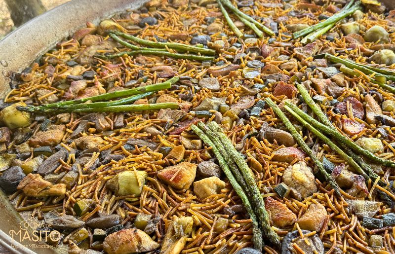 Fideuá de carne y verduras cocinada en paellera con sofrito casero