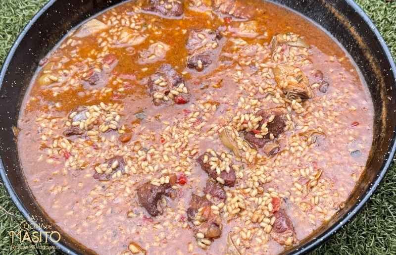 Arroz meloso de costillas y alcachofas servido recién hecho