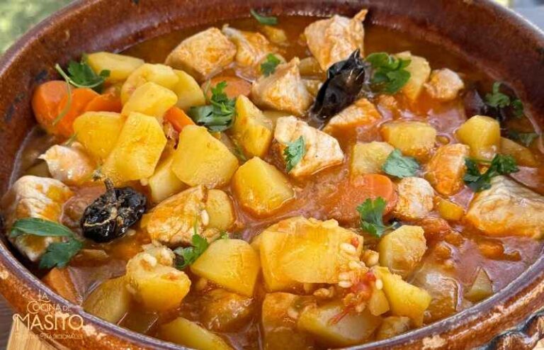 Plato de patatas con bonito y arroz en caldo casero servido en un plato hondo.