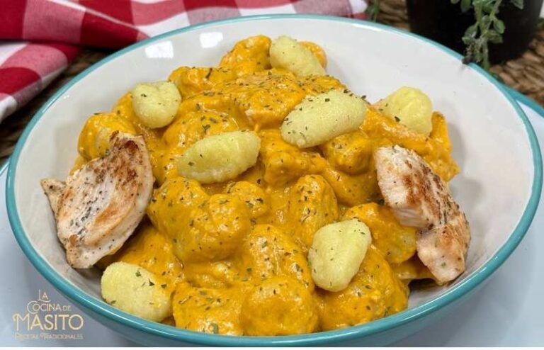 Ñoquis con pollo al curry servidos con salsa cremosa.