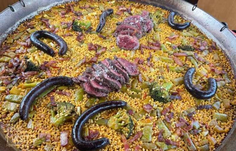 Detalle del arroz de la paella de solomillo de ternera con trozos de carne, bacon y verduras.