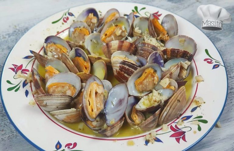 Plato de almejas al ajillo con perejil fresco y pan crujiente, ideal como aperitivo o entrante.