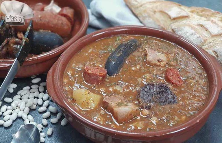 Cocido montañés tradicional, servido en un plato hondo, con alubias blancas, berza y embutidos caseros de La cocina de Masito