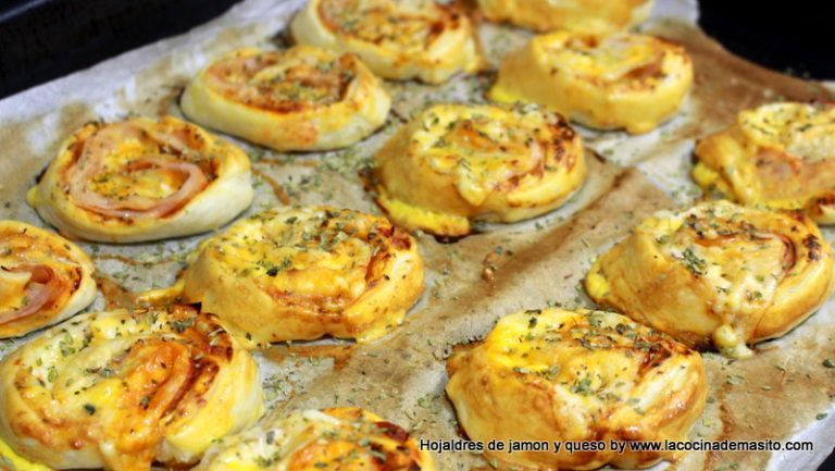 Rulos de hojaldre rellenos de jamón y queso, dorados al horno